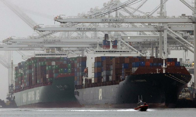 Container ships wait to be unloaded in the Port of Oakland in California in late October. The Commerce Department said Friday that the U.S. economy in the fourth quarter expanded at a slower pace than initially estimated. 