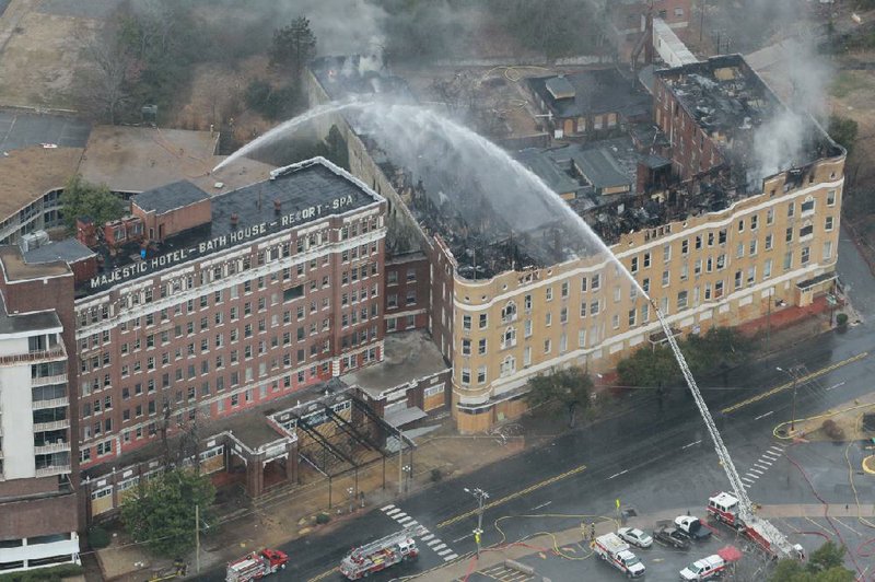 Firefighters battle the blaze Friday at Hot Springs’ historic Majestic Hotel and work to protect nearby buildings. 