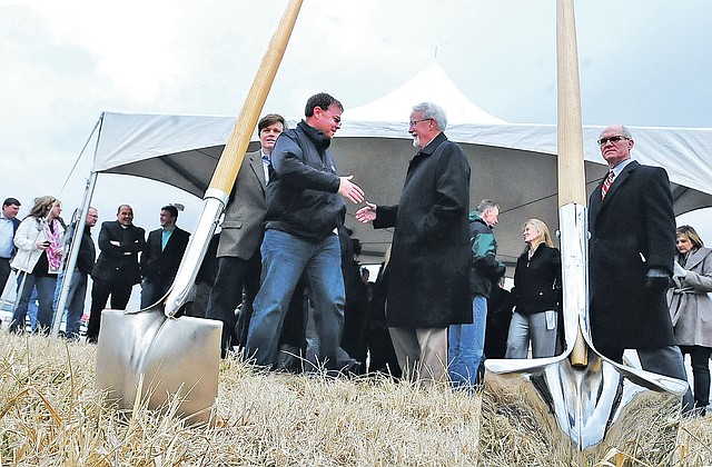 STAFF PHOTO FLIP PUTTHOFF Burke Larkin with Whisinvest Realty, front left, and guests gather to break ground Friday for Pleasant Crossing Shops, a retail center at 2600 W. Pleasant Crossing Drive near Interstate 540 in Rogers.