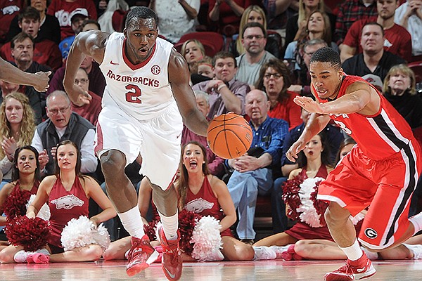 Arkansas' Alandise Harris, center, flies back down the court and through Brandon Morris, left, and Juwan Parker, both of Georgia, Saturday, March 1, 2014, during the second half of the game at Bud Walton Arena in Fayetteville