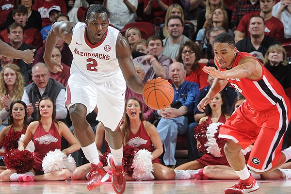 Arkansas' Alandise Harris, center, flies back down the court and through Brandon Morris, left, and Juwan Parker, both of Georgia, Saturday, March 1, 2014, during the second half of the game at Bud Walton Arena in Fayetteville