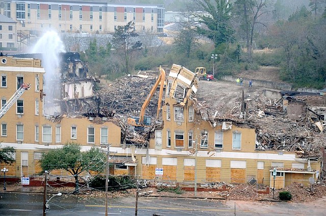 Crews in Hot Springs work Saturday on the demolition of the Majestic Hotel after a fire that started Thursday evening damaged the historic structure beyond repair