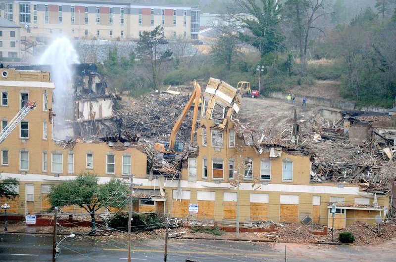 Crews in Hot Springs work Saturday on the demolition of the Majestic Hotel after a fire that started Thursday evening damaged the historic structure beyond repair