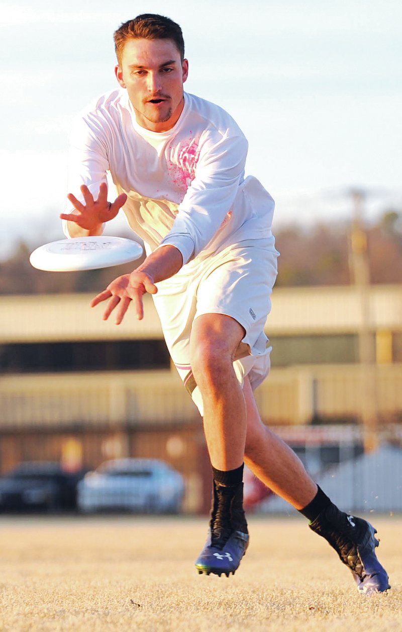 STAFF PHOTO ANDY SHUPE Austin Culp catches a disc during practice Thursday in Fayetteville.