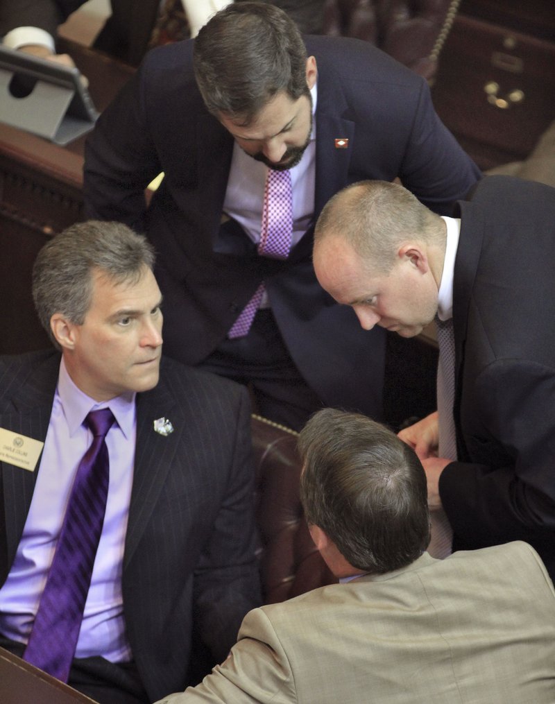 Arkansas Democrat-Gazette/BENJAMIN KRAIN State Rep. Charlie Collins, R-Fayetteville, left, House Minority Leader Greg Leding, D-Fayetteville, top, Jeff Wardlaw, D-Warren, right, and Rep John Burris, R-Harrison, discuss funding for the private option to expand Medicaid coverage during a recent House session in Little Rock.