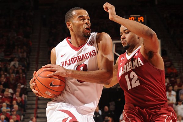 Arkansas senior Rickey Scott, left, drives to the lane as Alabama senior Trevor Releford defends during the first half of play Wednesday, Feb. 5, 2014, in Bud Walton Arena in Fayetteville.