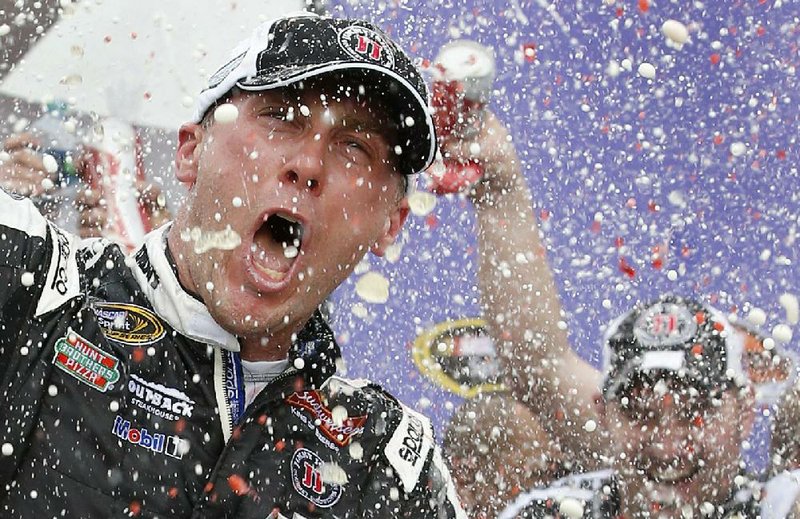 Kevin Harvick celebrates in Victory Lane with his crew after winning the NASCAR Sprint Cup Series auto race Sunday, March 2, 2014, in Avondale, Ariz. (AP Photo/Ross D. Franklin)
