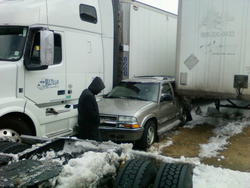 A driver assesses damage Monday, March 3, 2014, after a wreck on Interstate 30, west of University Avenue in Little Rock, involved multiple vehicles including four tractor-trailers and a state Highway Department sand truck.