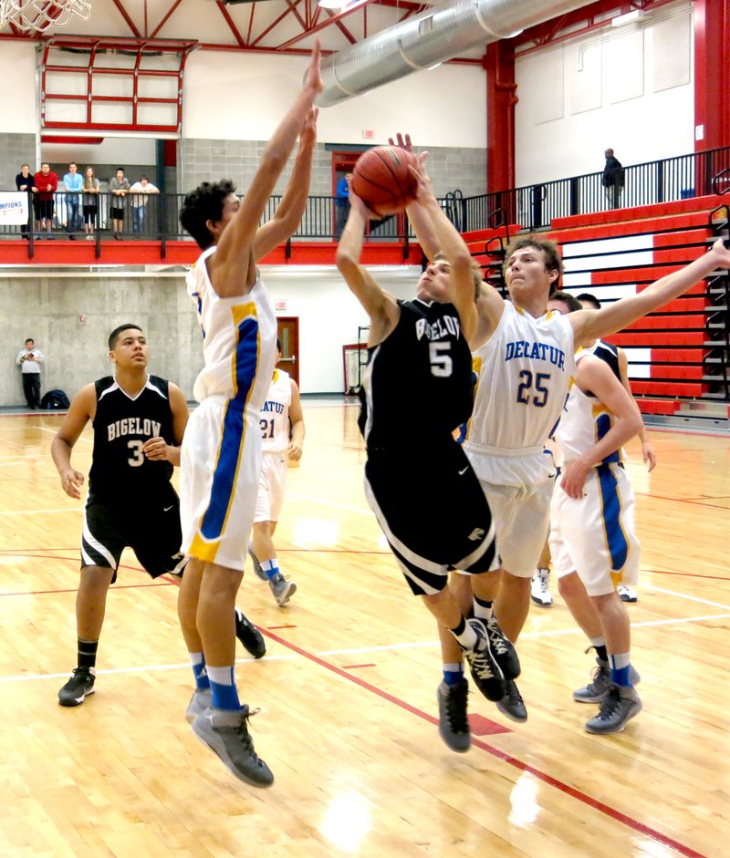 Photo by Mike Eckels Decatur's Victor Urquidi (#25 ) tries to strip the ball away from a Bigelow shooter while Mario Urquidi (#5) blocks from the front. Decatur played Bigelow in the first round of regional playoffs in Eureka Springs Feb. 26.