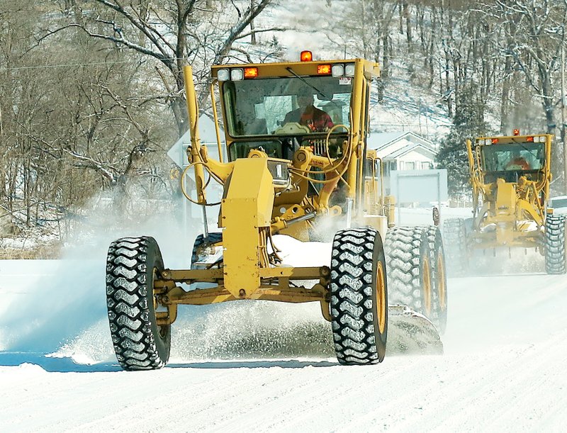 Photo by Randy Moll A pair of road graders scrape snow from Arkansas Highway 59 on the hill south of Gravette on Monday morning following a late blast of freezing rain, sleet and snow over the weekend. For more photos of the wintry blast which struck the area, see Page 6B.