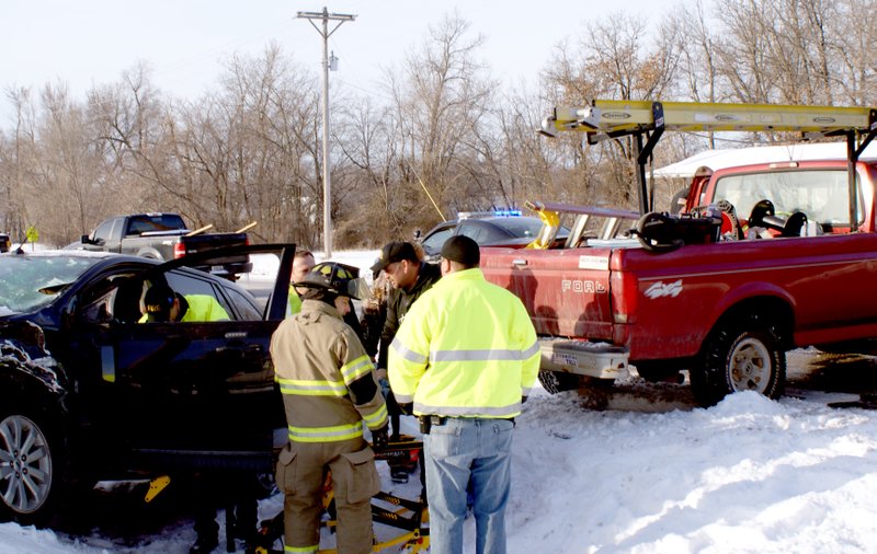 Photo by Dodie Evans Gravette emergency personnel prepare to extricate the driver of an auto which collided with a pickup truck at the overpass intersection of Hwys. 59 and 72. The accident occurred about 8 a.m. Tuesday, March 4. Details of the accident were not available at press time.