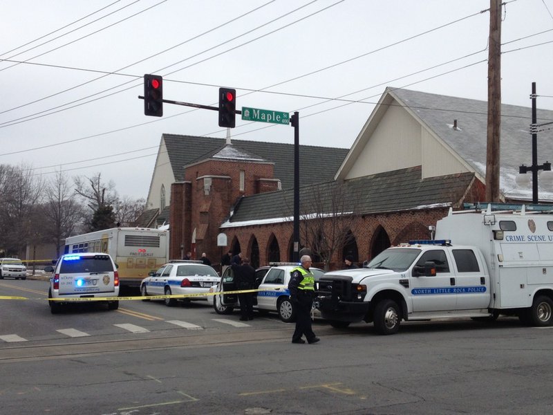 Crime scene tape blocks off Fourth Street between Maple and Orange in downtown North Little Rock on Wednesday, March 5, 2014. A city bus is within the crime scene.