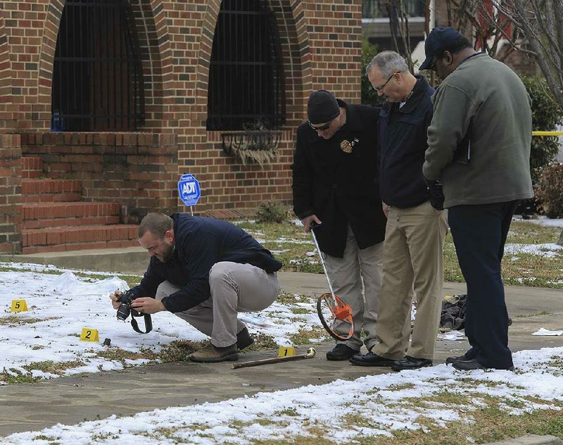 North Little Rock police officers gather evidence Wednesday afternoon at the scene of an officer-involved shooting in front of First Presbyterian Church at the corner of West Fourth and Maple streets in downtown North Little Rock. Police say a man causing a disturbance on a city bus was fatally shot after being removed from the bus and attacking an officer with a wooden cane. 