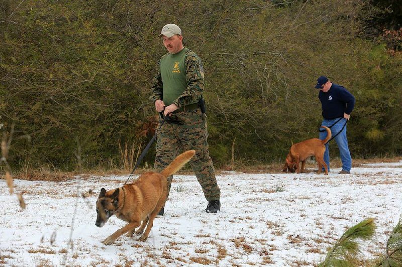 Capt. Robert Tycer of Angola, La., lets his Belgian Malinois, Kyra, practice her skills Wednesday at the Southern States Manhunt Field Trials at Camp Robinson in North Little Rock. 