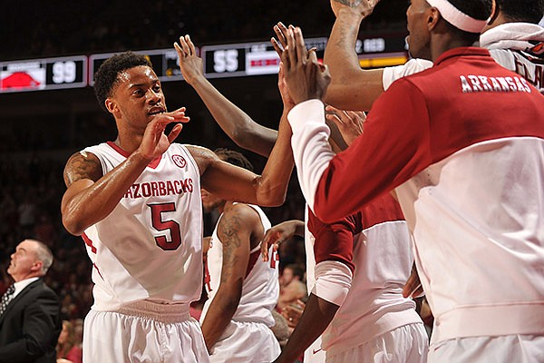 Arkansas guard Anthlon Bell gets high fives from his teammates as he leaves the game in the second half of Wednesday night's game against Ole Miss at Bud Walton Arena in Fayetteville.