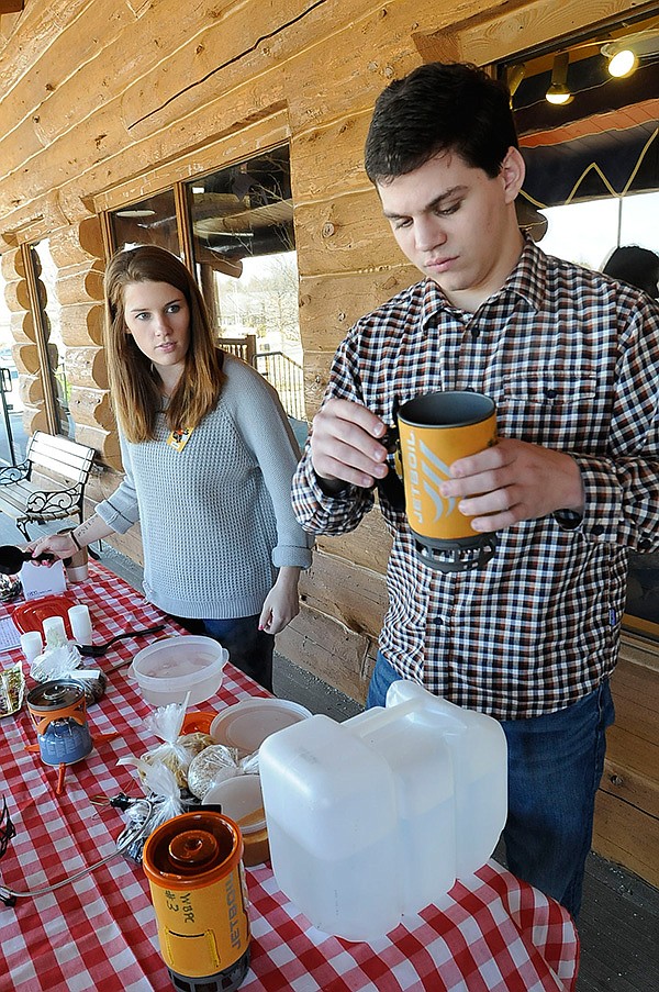Miriam Daniel, left, and Hugh Brewer whip up some oatmeal in a backpack-style stove.