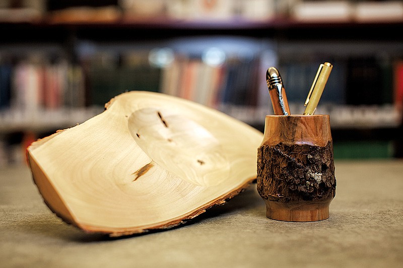 Above: A bowl made of white oak and walnut, left, and a container turned of dogwood that holds a couple of pens are a few of the items on display at the Bob Herzfeld Memorial Library in Benton as part of an exhibition of pieces produced by members of the Central Arkansas Woodturners.