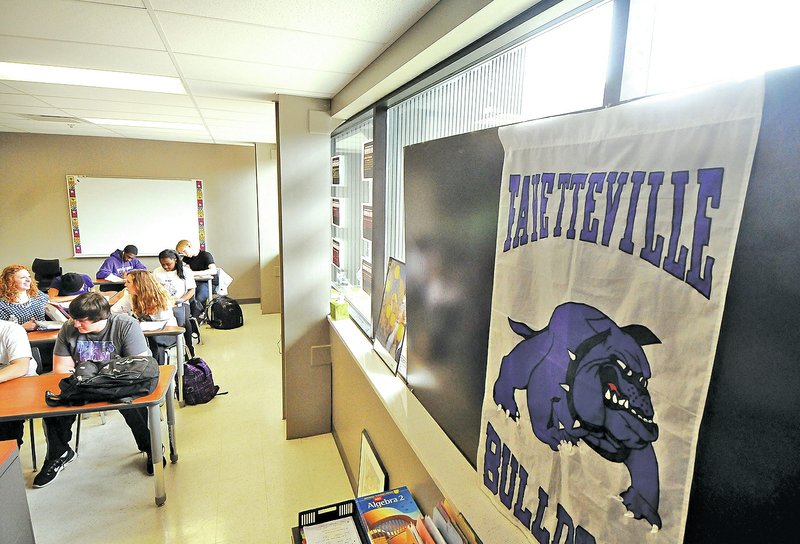 STAFF PHOTO BEN GOFF Posters hang Friday in the windows of a classroom at Fayetteville High School to block sunlight. With no blinds yet installed in the new building, teachers and students have improvised ways to block harsh direct light.