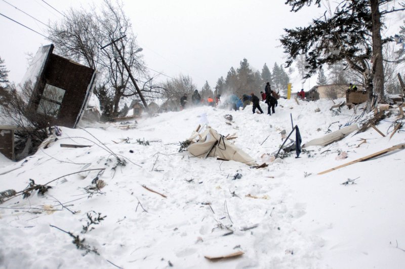 Rescuers dig at the scene of an avalanche in Missoula's Rattlesnake Valley on Friday, Feb. 28, 2014. The avalanche roared into a residential neighborhood and destroyed a house, but three people were found alive amid the snow and wreckage, police said. The survivors were an elderly couple and an 8-year-old boy, police Sgt. Travis Welsh said.
