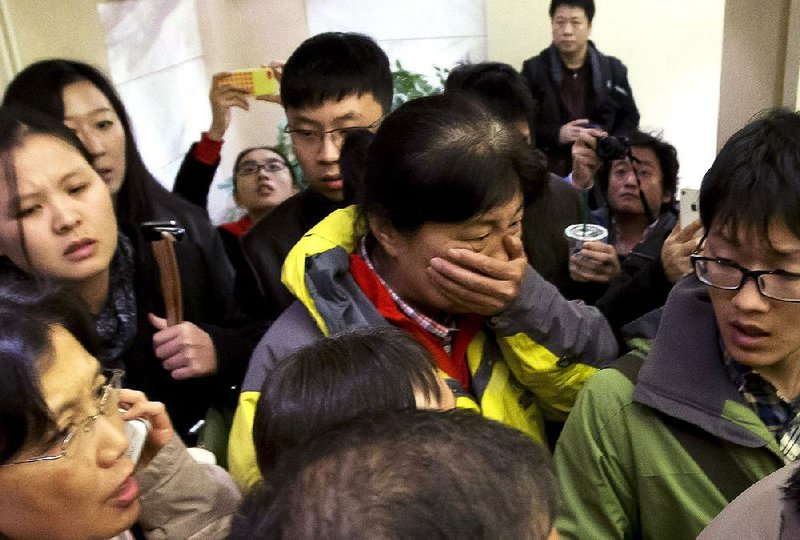 A woman arrives Saturday at a hotel in Beijing that was prepared for relatives and friends of passengers of the missing Malaysia Airlines flight. 