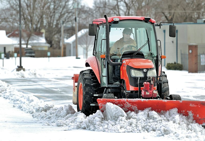 FILE PHOTO JASON IVESTER Michael Thomas, head groundskeeper, scrapes snow and ice from the parking lot Feb. 5 at Heritage High School in Rogers. &#8220;We&#8217;ve had really mild winters, so I guess we got spoiled to thinking it&#8217;s normal. This is winter,&#8221; Mike Borengasser said with a laugh. Borengasser is a climatologist with the state.