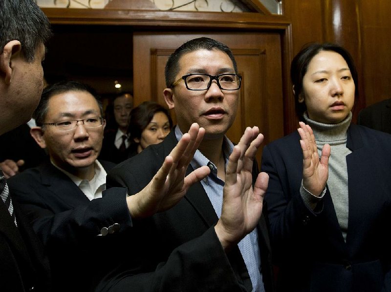 CEO of Malaysia Airlines Ignatius Ong, center, gestures as he prepares to speak to the media outside a hotel room for relatives or friends of passengers aboard a missing Malaysia Airlines airplane in Beijing, China Monday, March 10, 2014. Vietnamese aircraft spotted what they suspected was one of the doors of the missing Boeing 777 on Sunday, while questions emerged about how two passengers managed to board the ill-fated aircraft using stolen passports. (AP Photo/Andy Wong)