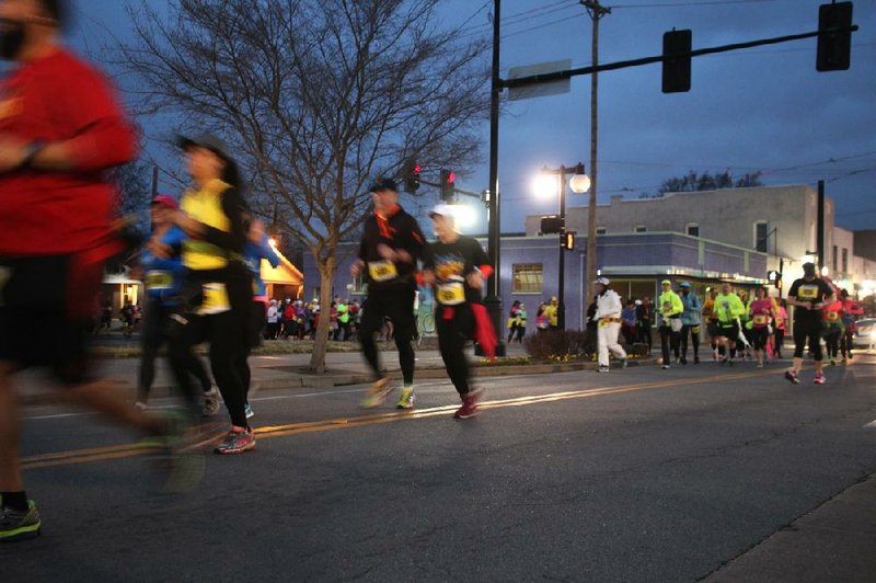 Arkansas Democrat-Gazette/CELIA STOREY
Participants in the LIttle Rock Marathon's early start round the corner of Seventh and Main streets in North LIttle Rock before dawn March 2.