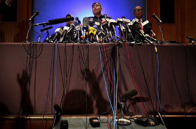 Microphones crowd a table Tuesday as Malaysian Police Chief Khalid Abu Bakar answers questions from members of the media during a news conference in Sepang, Malaysia. 