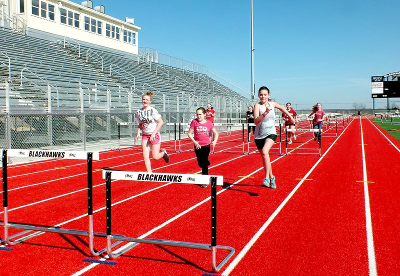 TIMES photograph by Annette Beard Seventh-grade track athletes practice on the new track with hurdles. A junior high track meet was slated for Tuesday afternoon for the first track meet hosted by Pea Ridge.