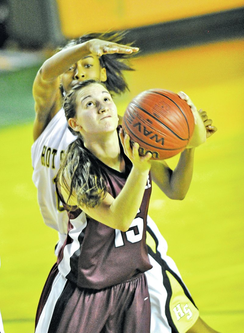  Staff Photo Michael Woods • @NWAMICHAELW Vanessa Burgess of Huntsville drives to the basket past Hot Springs defender Tiaunnal Watkins during the second half of Tuesday's playoff game in the Class 5A Basketball Tournament at Alma.