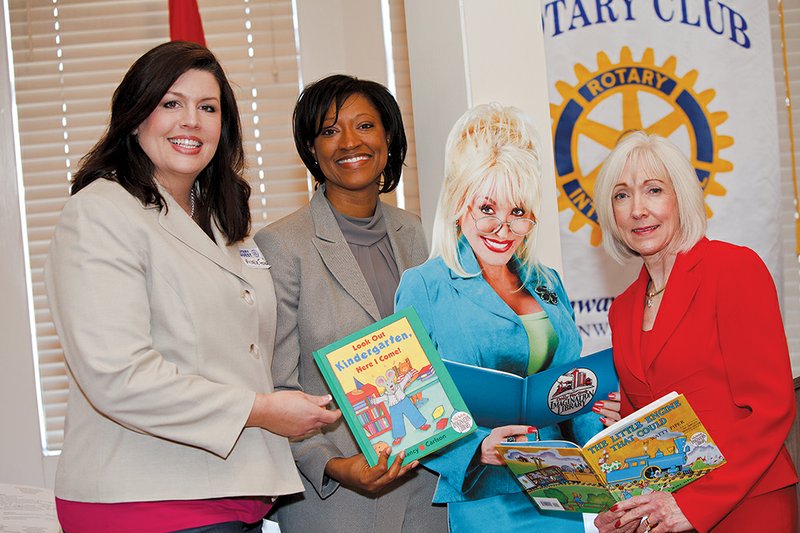 From the left, Michelle Ford, program director for Arkansas Preschool Plus in Conway; Charlotte Green, executive director of Arkansas Preschool Plus; and first lady Ginger Beebe stand with a cardboard cutout of singer Dolly Parton, who founded Imagination Library to provide free books for a year to children from birth to 5 years old. At a Conway Rotary Club meeting, Arkansas Preschool Plus announced that it is an Imagination Library affiliate.