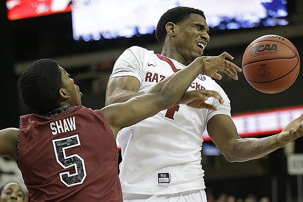 Arkansas forward Coty Clarke (4) and South Carolina guard Jaylen Shaw (5) vie for a loose ball during the first half of an NCAA college basketball game in the second round of the Southeastern Conference men's tournament, Thursday, March 13, 2014, in Atlanta. (AP Photo/Steve Helber)