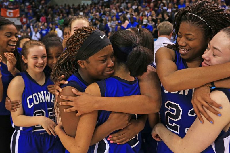 Arkansas Democrat-Gazette/RICK MCFARLAND --03/13/14--  Conway's Asia Willard (left center) hugs Alexis Tolefree as India Lattimore (24) hugs Hailey Estes (far left) after beating FT Smith Northside's in the State Class7A Girls  Championship game in Hot Springs Thursday.