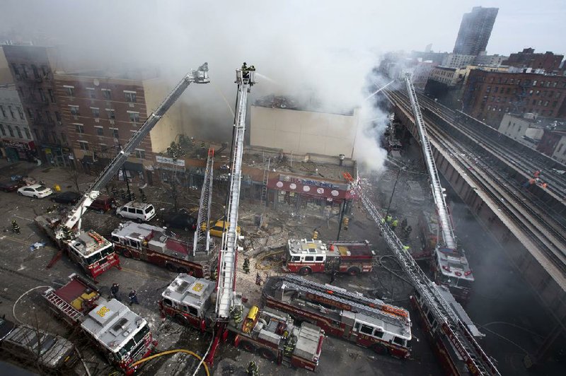Firefighters battle a fire after a building collapses in the East Harlem neighborhood of New York, Wednesday, March 12, 2014 (AP Photo/John Minchillo)
