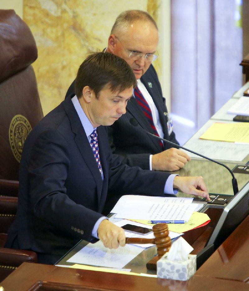 With parliamentarian Buddy Johnson at his side, House Speaker Davy Carter, R-Cabot, bangs the gavel for a fi nal time Wednesday before lawmakers head home. Legislators will return briefly next week before the Legislature formally adjourns. 