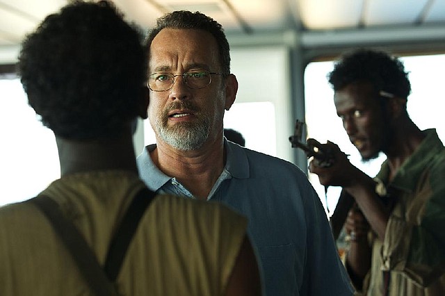 Tom Hanks (center), widely regarded as the most trusted man in America, is shown in a scene from Captain Phillips, where he plays a heroic real-life merchant mariner who is not nearly as well known. 