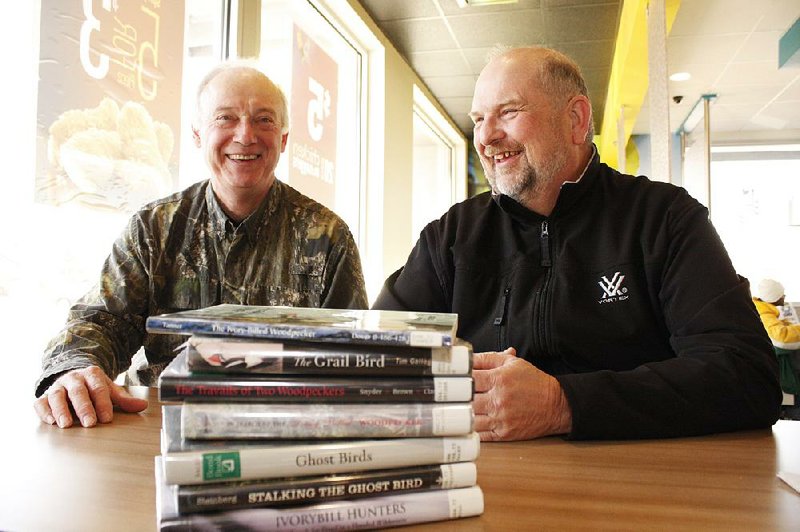 Tim Gallagher and Bobby Harrison sit inside the Brinkley McDonald’s before a stack of books, including Gallagher’s The Grail Bird: Hot on the Trail of the Ivory-billed Woodpecker. 