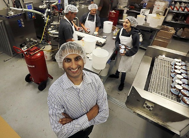 In this Tuesday, Feb. 18, 2014 photo, Amit Pandhi, chief executive officer of Arctic Zero, which makes a no-fat frozen dessert, poses at the company's factory in Pomona, Calif.  The makers of Arctic Zero started small, selling their frozen dessert to natural food stores and independent grocers in Southern California. It took years and lots of traveling to get the product on the shelves of major chains like Whole Foods and Wal-Mart. (AP Photo/Reed Saxon)