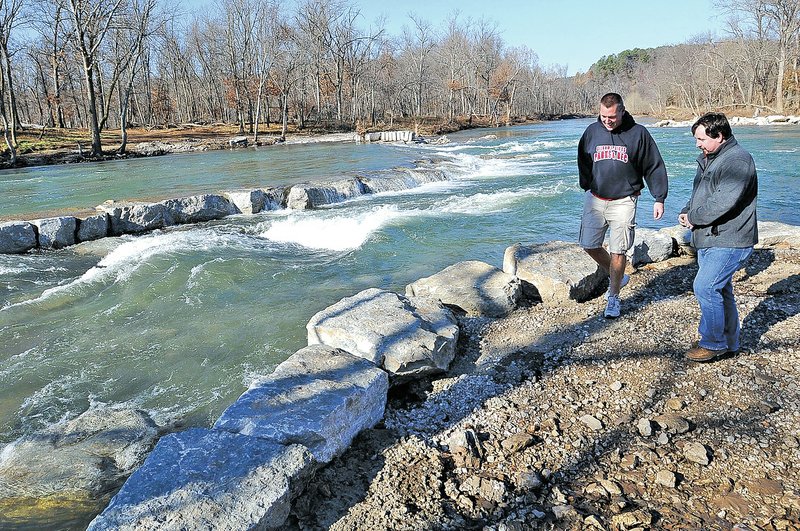 FILE PHOTO FLIP PUTTHOFF Scott Hodge, left, Siloam Springs parks and recreation manager, and David Vansandt with the city&#8217;s parks advisory board, have a look at the whitewater park being built on the Illinois River on the south edge of Siloam Springs. A new U.S. Geological Survey study says whether a stream in the river&#8217;s watershed is healthy depends on more than whether there&#8217;s a poultry farm.