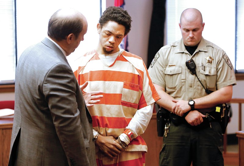 STAFF PHOTO DAVID GOTTSCHALK Mandrake Patterson, center, speaks Friday with attorney Gregg Parrish in Judge William Storey&#8217;s courtroom at the Washington County Courthouse in Fayetteville after he pleaded guilty to two counts of capital murder and one count of attempted capital murder in an exchange for life sentences.