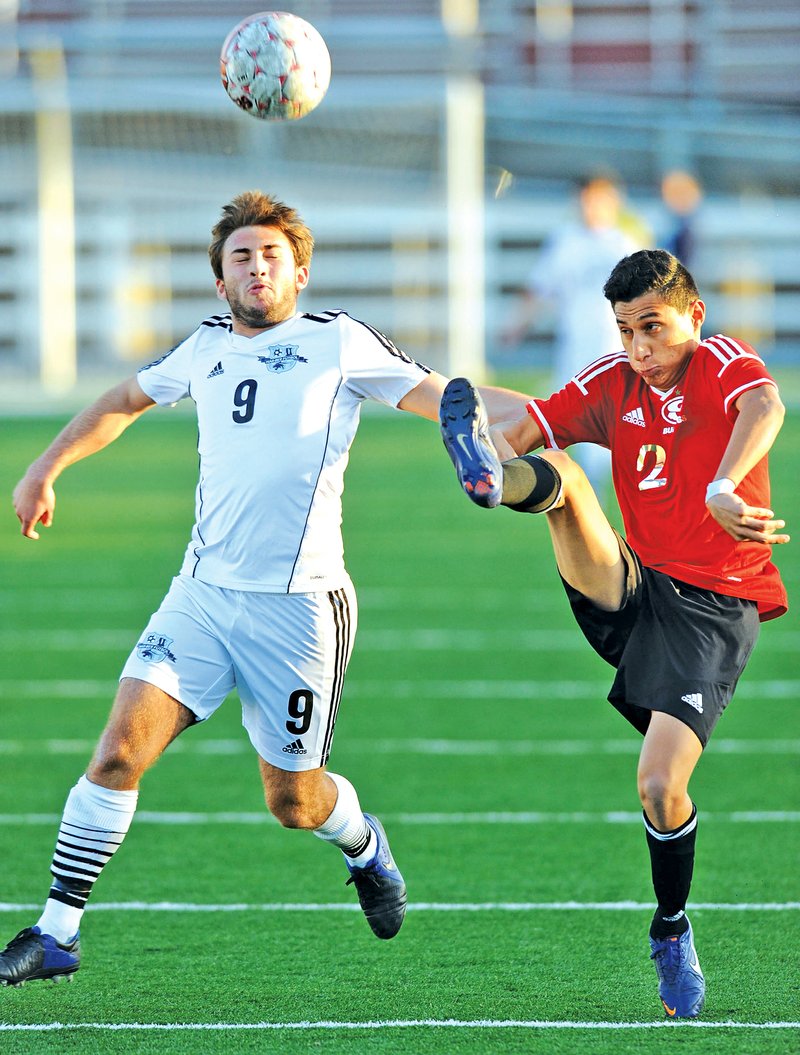 STAFF PHOTO ANDY SHUPE Erick Avilez, right, of Springdale High and Cole Brothers of Springdale Har-Ber vie for the ball Friday at Jarrell Williams Bulldog Stadium in Springdale.