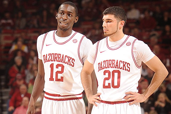 Arkansas guards and former Fayetteville High School standouts Fred Gulley (12) and Kikko Haydar speak Saturday, Jan. 5, 2013, during the second half of play against Delaware State in Bud Walton Arena in Fayetteville.