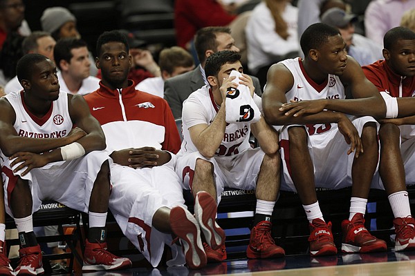 Arkansas players sit on the bench during the second half of an NCAA college basketball game against South Carolina in the second round of the Southeastern Conference men's tournament, Thursday, March 13, 2014, in Atlanta. (AP Photo/John Bazemore)