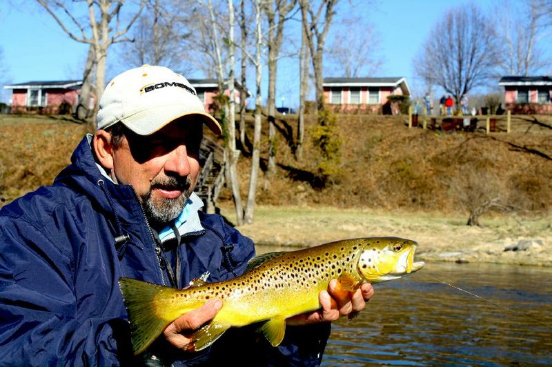 Frank Saksa, a fishing guide on the White River, admires a brown trout he caught in this file photo.