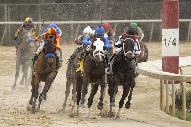 Mike Smith, left front, raises his whip as he and Hoppertunity begin to move on Strong Mandate, center, with Joel Rosario aboard, and Ride On Curlin, front right, with Kent Desormeaux aboard, in the far turn of the Rebel Stakes horse race at Oaklawn Park in Hot Springs, Ark., Saturday, March 15, 2014. (AP Photo/David Quinn)