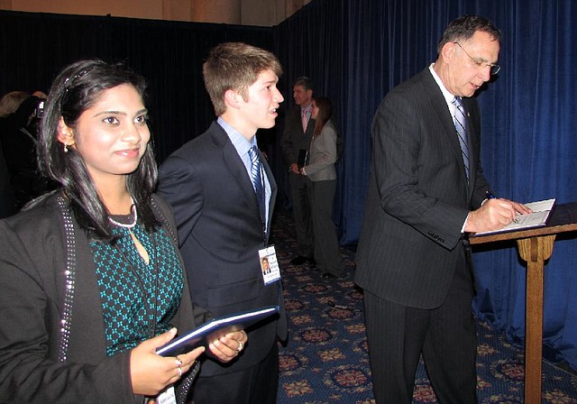 U.S. Sen. John Boozman, R-Ark, signs certificates for Abhilasha Gokulan (left) of Little Rock and Adam Williams of Jonesboro at a reception in Washington. The students are delegates in the U.S. Senate Youth Program. 