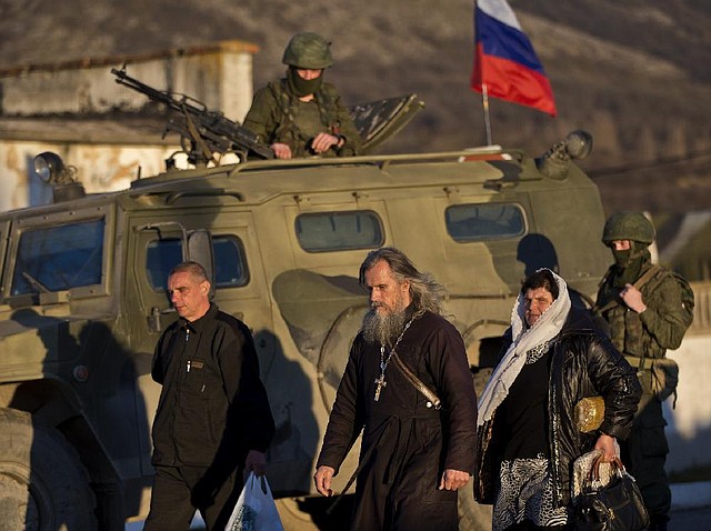 Ukrainian Orthodox Archbishop Clement walks past an armored vehicle Saturday outside a Ukrainian army base in Perevalne in Crimea, which votes today on splitting from Ukraine. 