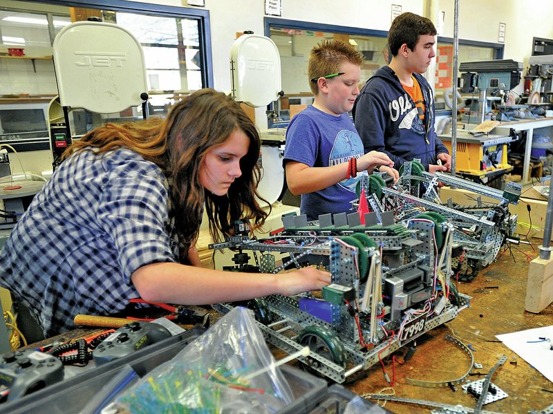STAFF PHOTO MICHAEL WOODS 
• @NWAMICHAELW 
Tanner Davis, from left, Reece Williams and Noah Wehn, all Southwest Junior High School students, work on a pair of robots Thursday in Springdale. Students from the Vex Robotics Club at Southwest will compete in the Vex Robotic World Championships in Anaheim, Calif., in April.
