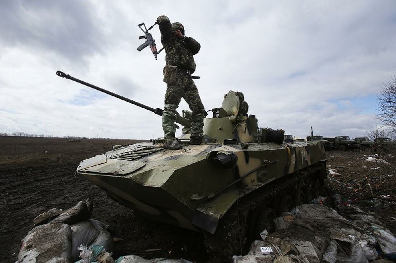 A Ukrainian soldier stands atop an armored vehicle at a military camp near the village of Michurino, Ukraine, Monday, March 17, 2014. Addressing lawmakers in Ukraine's parliament on Monday, Olexandr Turchynov, the acting president, described Sunday's Crimean poll as a farce that would "never be recognised by Ukraine and the civilised world". He also signed a decree to mobilise volunteers and reservists. (AP Photo/Sergei Grits)
