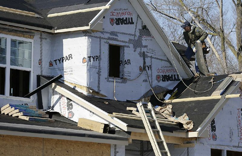 FILE - In this Dec. 27, 2013 file photo, a builder works on the the roof of a new home under construction in Wilmette, Ill. The National Association of Home Builders reports on sentiment among U.S. builders on Monday, March 17, 2014. (AP Photo/Nam Y. Huh, File)